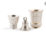 deux coupes en argent et une clochette en argent sur fond blanc