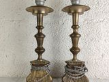 pair of antique brass candlesticks on a white tablecloth