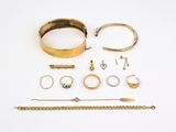 de nombreuses bagues et bracelets en or posés sur un fond blanc