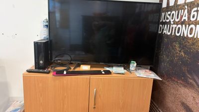 une télévision à écran plat posée sur un meuble en bois