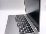 a silver laptop with a black keyboard on a white surface