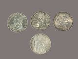 four different types of coins are shown on a gray background