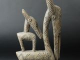 a sculpture of a bird and a bird sitting on top of a chair