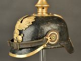 an old helmet with a gold decoration on it on a stand