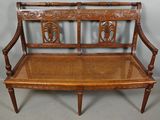 a wooden bench with a wicker seat on top of it