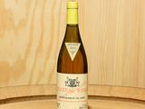 une bouteille de vin posée sur un tonneau