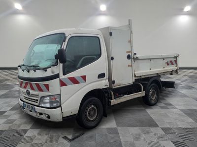un camion blanc garé sur un sol à damier