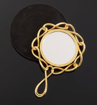 a close up of a mirror on a black surface with a chain around it