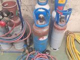de nombreux types différents de bouteilles de gaz et de tuyaux, disposés les uns à côté des autres