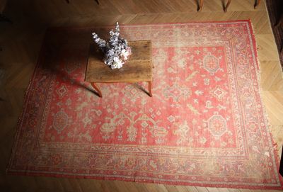 un tapis rouge posé sur un parquet, à côté d'une table basse