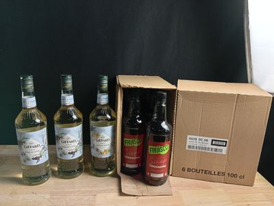 Plusieurs bouteilles d'alcool sont posées dans une boîte en carton sur une table