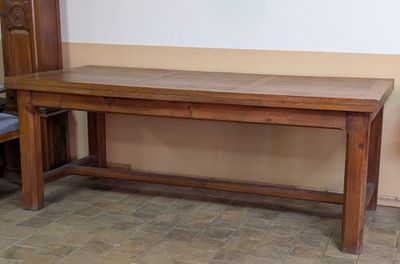a wooden table with a bench underneath it in a room