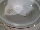 un bol blanc orné de fleurs dorées, posé sur une table
