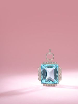 an image of a blue topaz stone and diamond pendant on a pink background