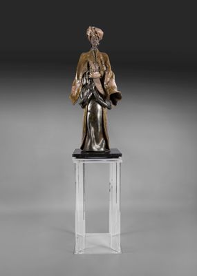 une statue en bronze représentant une femme tenant un enfant dans ses bras, posée sur un socle