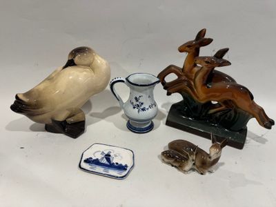 plusieurs figurines d'animaux et un vase posés sur une surface blanche