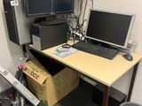 un bureau sur lequel sont posés deux écrans et un ordinateur portable