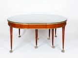 an oval dining table with a glass top and four legs