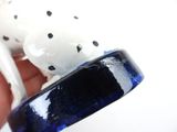 a person holding a white and black dalmatian dog figurine