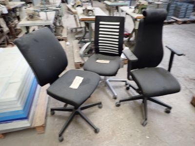 trois chaises de bureau qui se trouvent dans un entrepôt