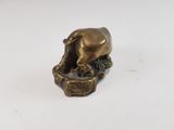 brass figurine of a bull on a rock with water in its mouth