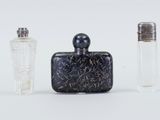 trois flacons de parfum posés l'un à côté de l'autre sur une surface blanche