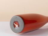 a wine bottle with a hole in it sitting on a table