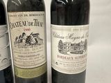 three bottles of wine are lined up on a white surface
