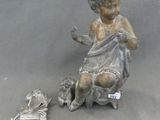 une statue représentant un enfant assis sur une chaise, un livre à la main
