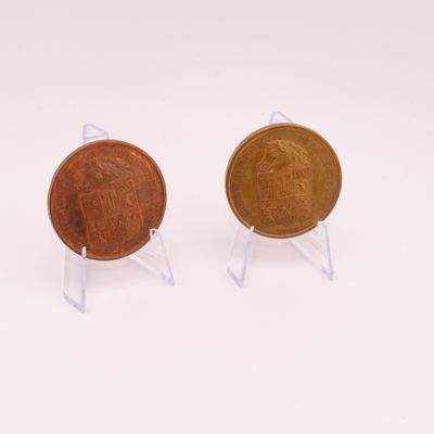 pair of two coins sitting on top of each other on a white surface