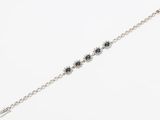 a close up of a silver bracelet with black stones on it
