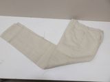 beige pants sitting on a white table with a pair of scissors on top of it