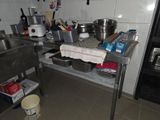 une cuisine équipée d'un évier, d'une cuisinière et d'autres éléments posés sur le plan de travail