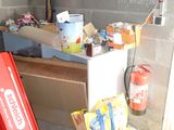 a red refrigerator in the corner of a room that is under construction