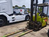 a fork lift truck parked next to a semi truck