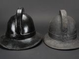 two helmets sitting next to each other on a black background