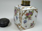 a small vase with a lid sitting next to a small box
