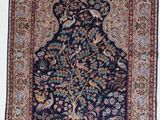 un tapis oriental accroché au mur, orné d'oiseaux et de fleurs