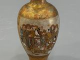 a gold vase with a picture of people on it