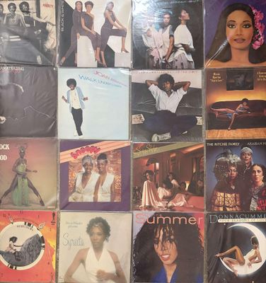 many different album covers on the wall of a room
