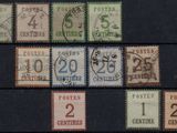 several different postage stamps on a black surface with a number of them