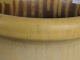 a large yellow vase with a brown stripe on it