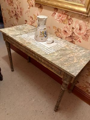 une table sur laquelle est posé un vase, devant un miroir
