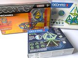 trois boîtes de jouets geoexo sont posées sur une surface blanche