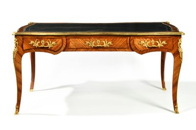 a desk with a black top and gold trimmings