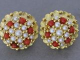 une paire de boucles d'oreilles en perles rouges et blanches et en or