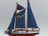 a small model of a sailboat with blue sails