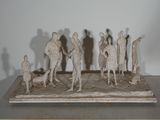 sculpture représentant un groupe de personnes debout sur une table