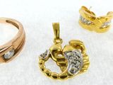 three pieces of gold and diamond jewelry on a white surface