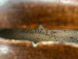 a close up of a brown leather bag with a label on it